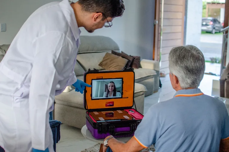 Médico atendendo paciente idoso com o Telekit® em consulta domiciliar